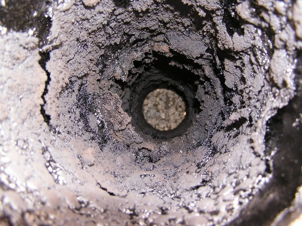 Conduit de cheminée encrassé de bistre et de suie avant ramonage, à Toulouse